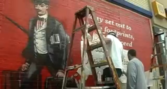 Men at work on hand painted advertising for Dewars Whisky in New York