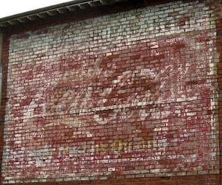 Faded hand painted sign on a wall advertising Coca-Cola