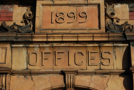 Relief lettering on stone saying "1899, Offices"