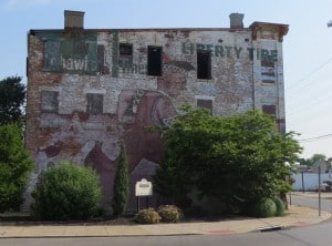 One side of a building entirely wrapped by a ghostsign for Liberty Tire