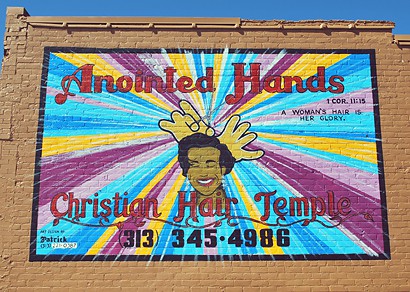 Brightly coloured hand painted sign for Anointed Hands Christian Hair Temple
