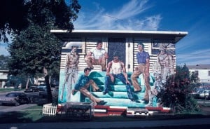 Mural depicting men hanging out on the steps of a house