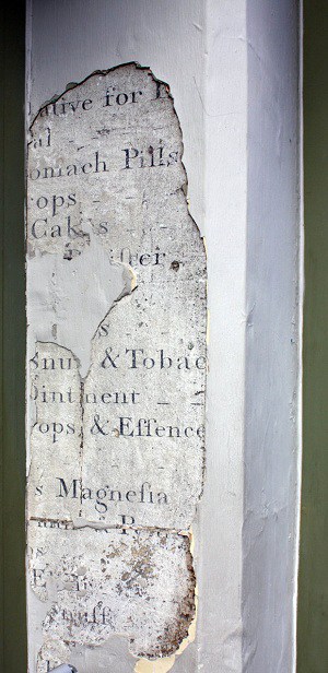 Portion of wall removed to reveal early 1800s hand painted sign