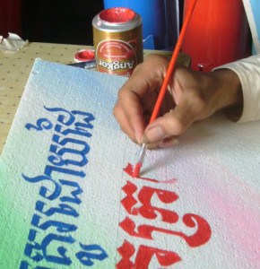 Cambodian signpainter creating a hand painted cover for the book, Hand Painted Signs of Kratie.