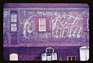 Hand painted sign on a wall advertising coca-cola