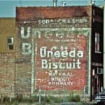Hand painted signs on a wall advertising Uneeda Biscuit