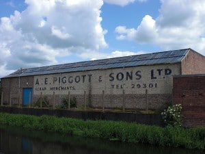 Hand-painted sign on the wall of a warehouse beside a canal