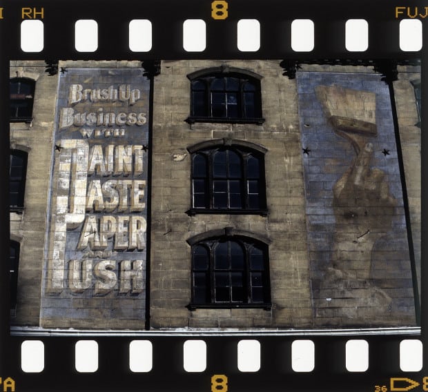 Photographic film showing large hand-painted sign on a wall in New York