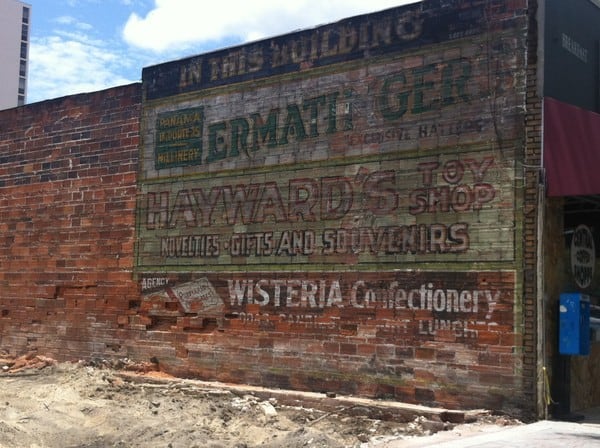 Hand-painted sign on a wall revealed after demolition of adjacent building.