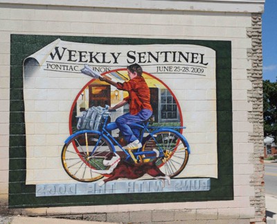 Hand-painted mural showing paperboy for the Weekly Sentinel