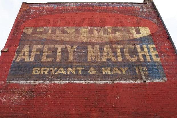 Fading hand-painted sign on a wall advertising Brymay matches