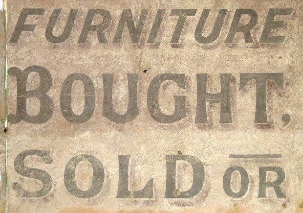 Hand-painted lettering on a wall saying 'Furniture Bought, Sold Or'