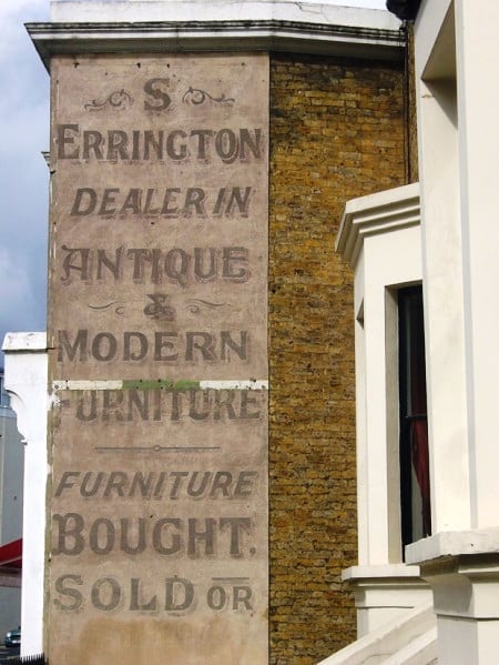 Faded hand-painted lettering on a wall (ghostsign) for S Errington furniture dealer