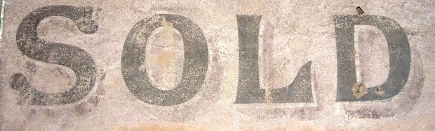 Hand-painted lettering on a wall saying 'Sold'