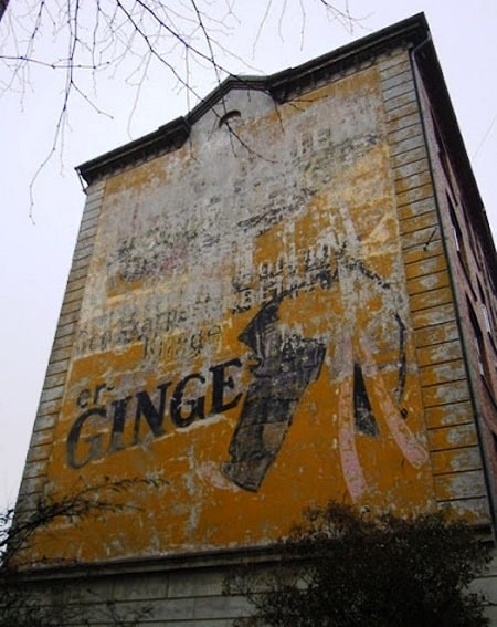 Faded piece of painted advertising on a wall promoting Ginge Razors