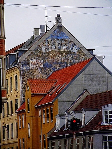 Fading painted sign high up on a wall advertising Hafnia Skinke Ham