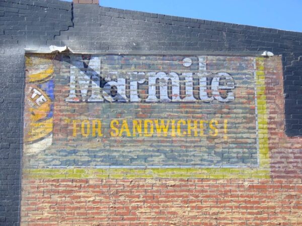 Partial fading painted sign on wall advertising Marmite