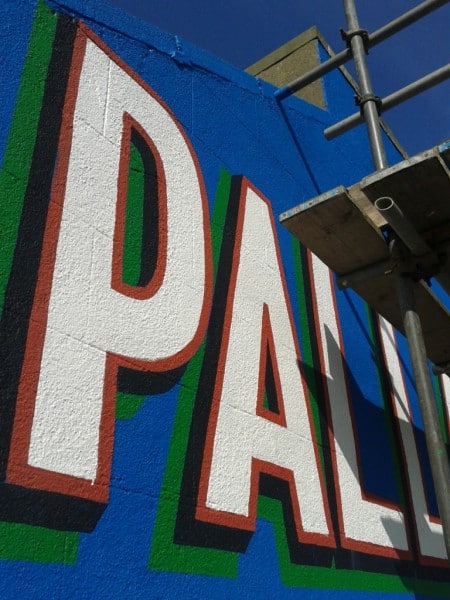 Repainted wall sign for Palladium cinema replicating fragments of colour from faded original