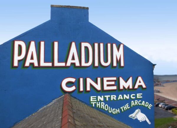 Repainted sign on a wall advertising the Palladium Cinema