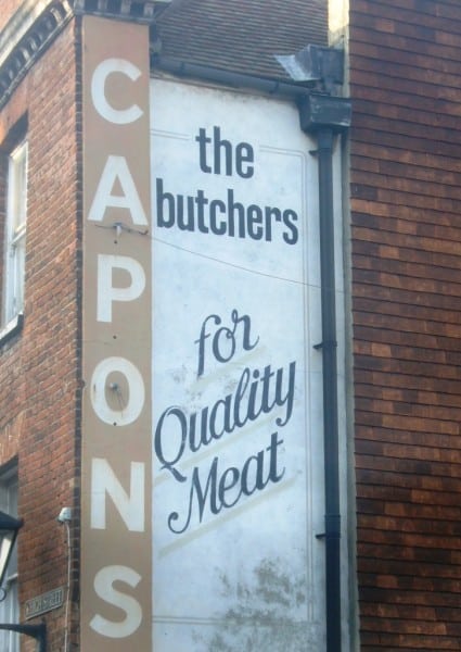Fading sign on wall for Capons Butchers
