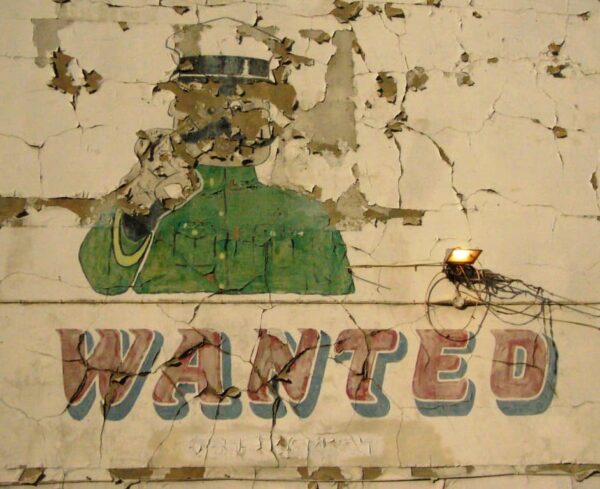 Detail of painted sign showing military general pointing and the word 'Wanted'
