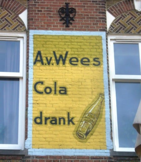 Painted sign on a wall for A.v.Wees Cola Drink