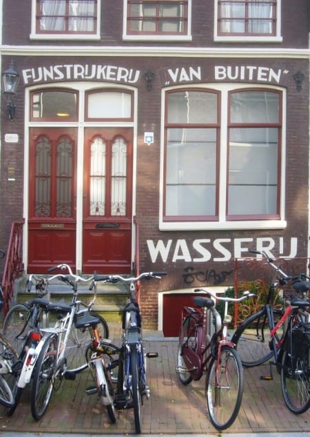Painted sign on the front of a building for Fijnstrijkerij Van Buiten