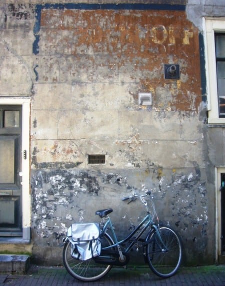 Fading painted sign on a wall and a bicycle