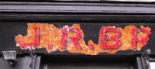 Part of shop fascia lettering showing through blackwash