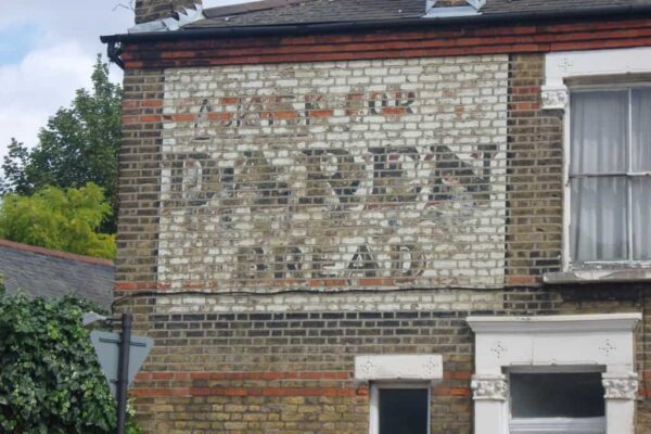 Fading painted sign on a wall advertising Daren Bread