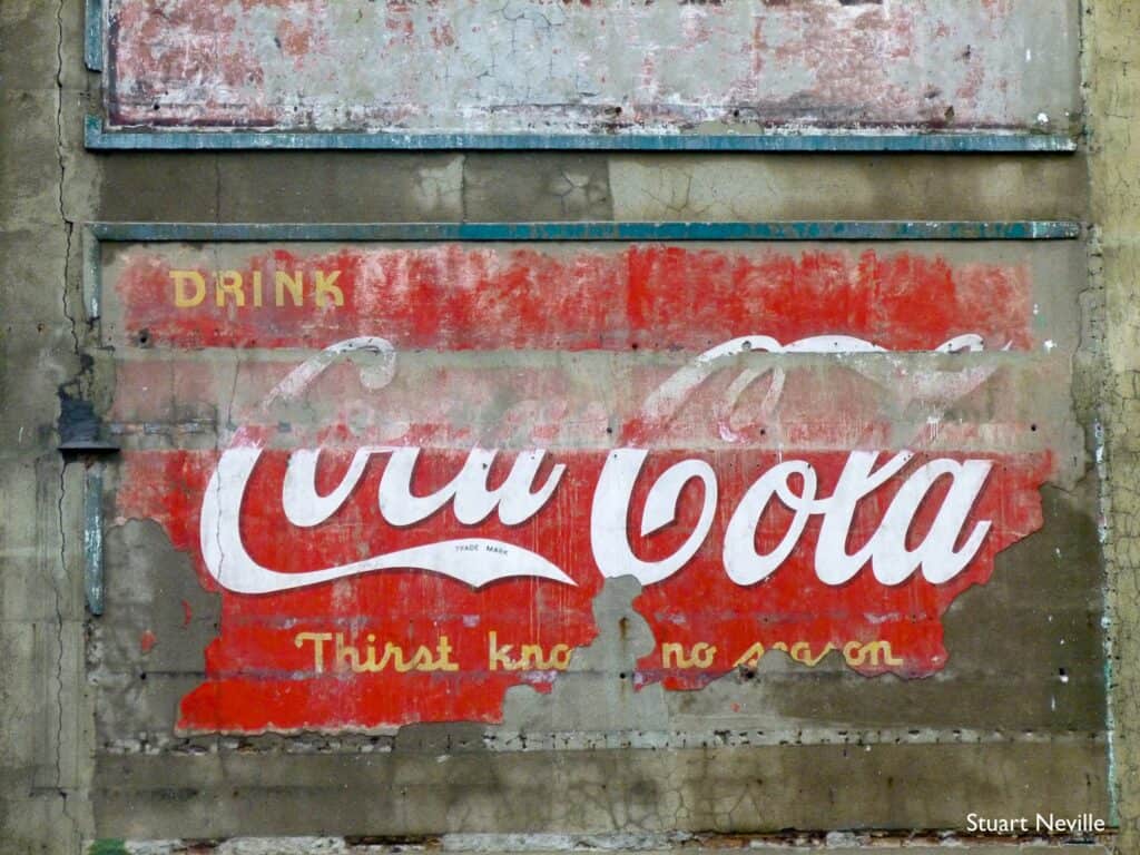 Fading painted sign on a wall for Coca-Cola.
