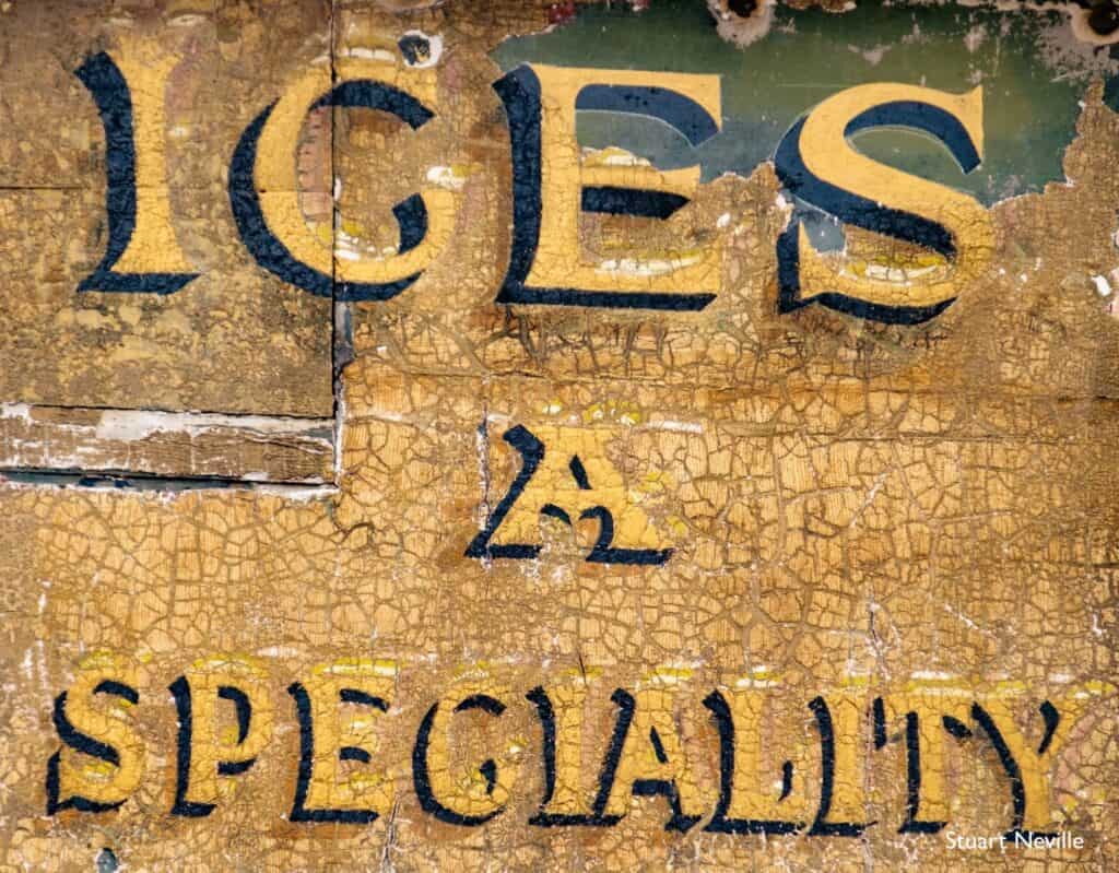 Fading painted sign saying 'Ices a Speciality'