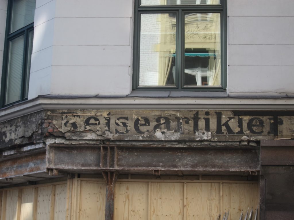 Fading and crumbling shop front sign.