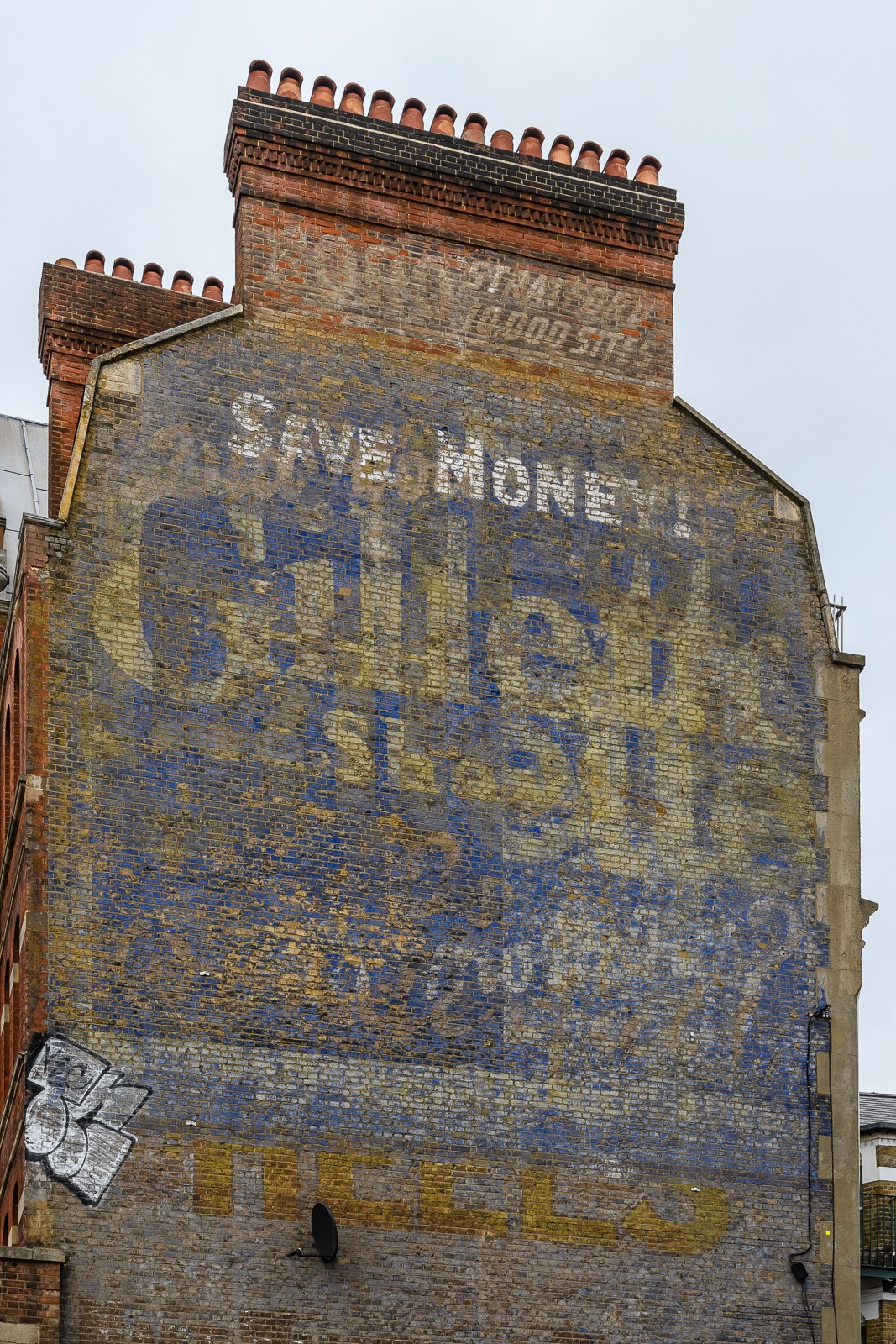 Multiple layers of fading painted advertising on a wall.