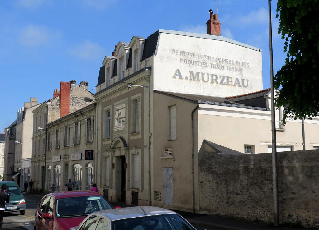 This photo shows the same sign in sunlight while the terraced street beyond is in shade.